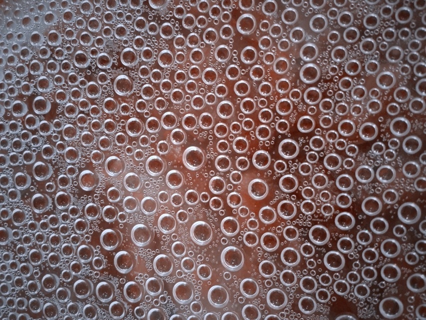 Condensation on the underside of the plastic wrap covering a bowl of chili. (2016, color graded)