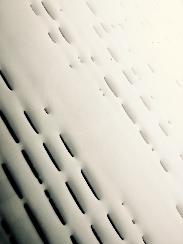 Dry snow fell through the space in between the slats of a wooden deck. (2017, color graded)