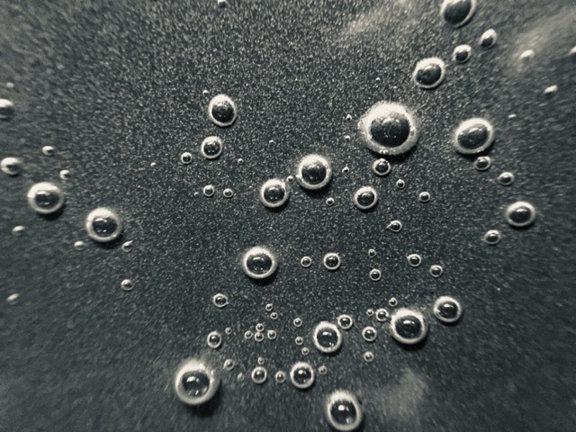 Bubbles forming at the bottom of a pot of water on the cusp of boiling. (2019)